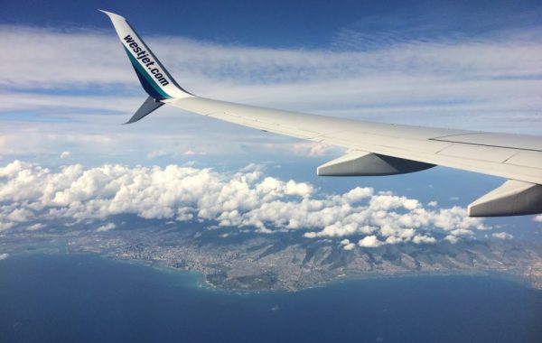 Plane wing with Oahu below, finding cheap flights